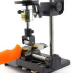 A precise load (the white tac on the platform is used to adjust the load) applies pressure to an 'impactor'.